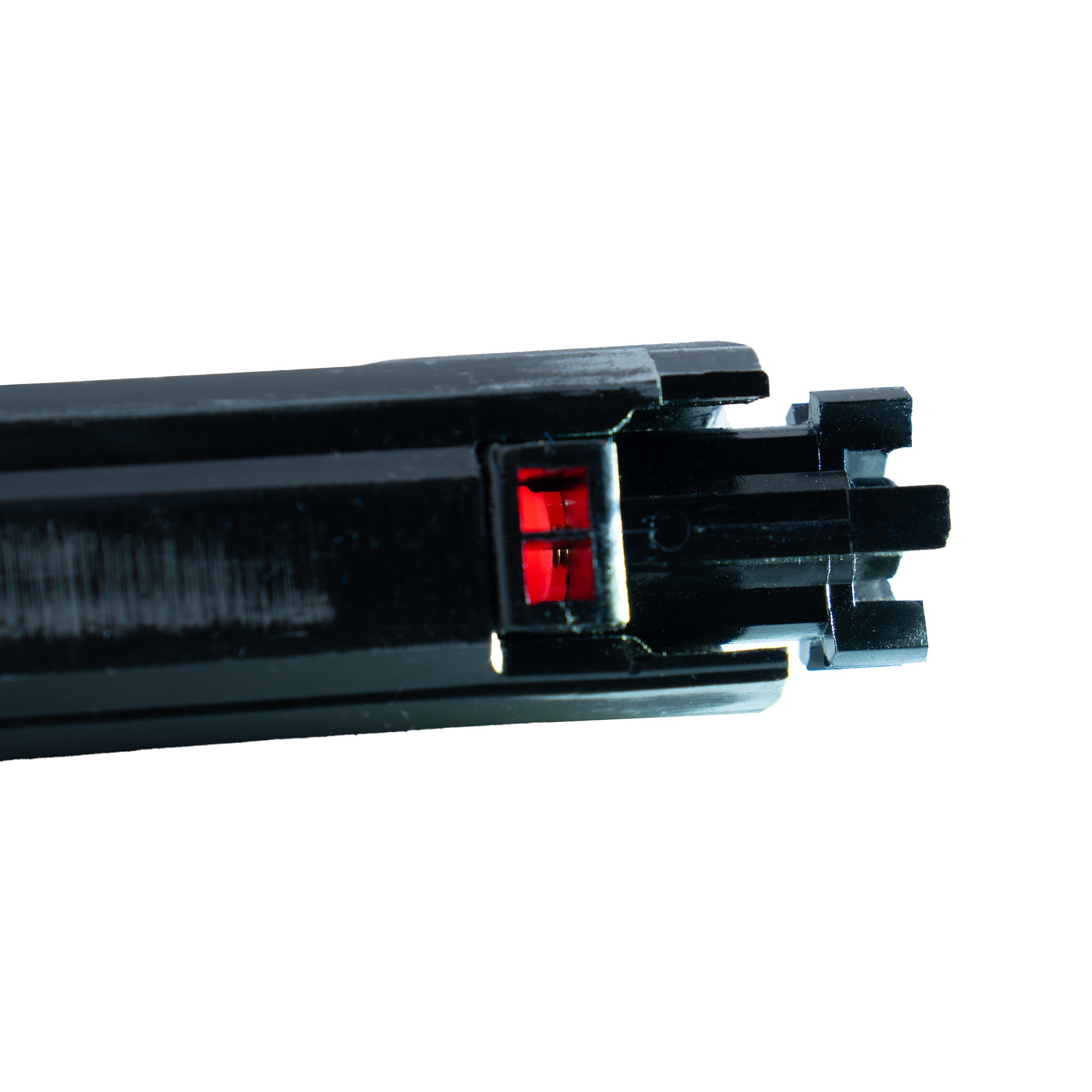 Close-up of a black metal component with a red light on a white background