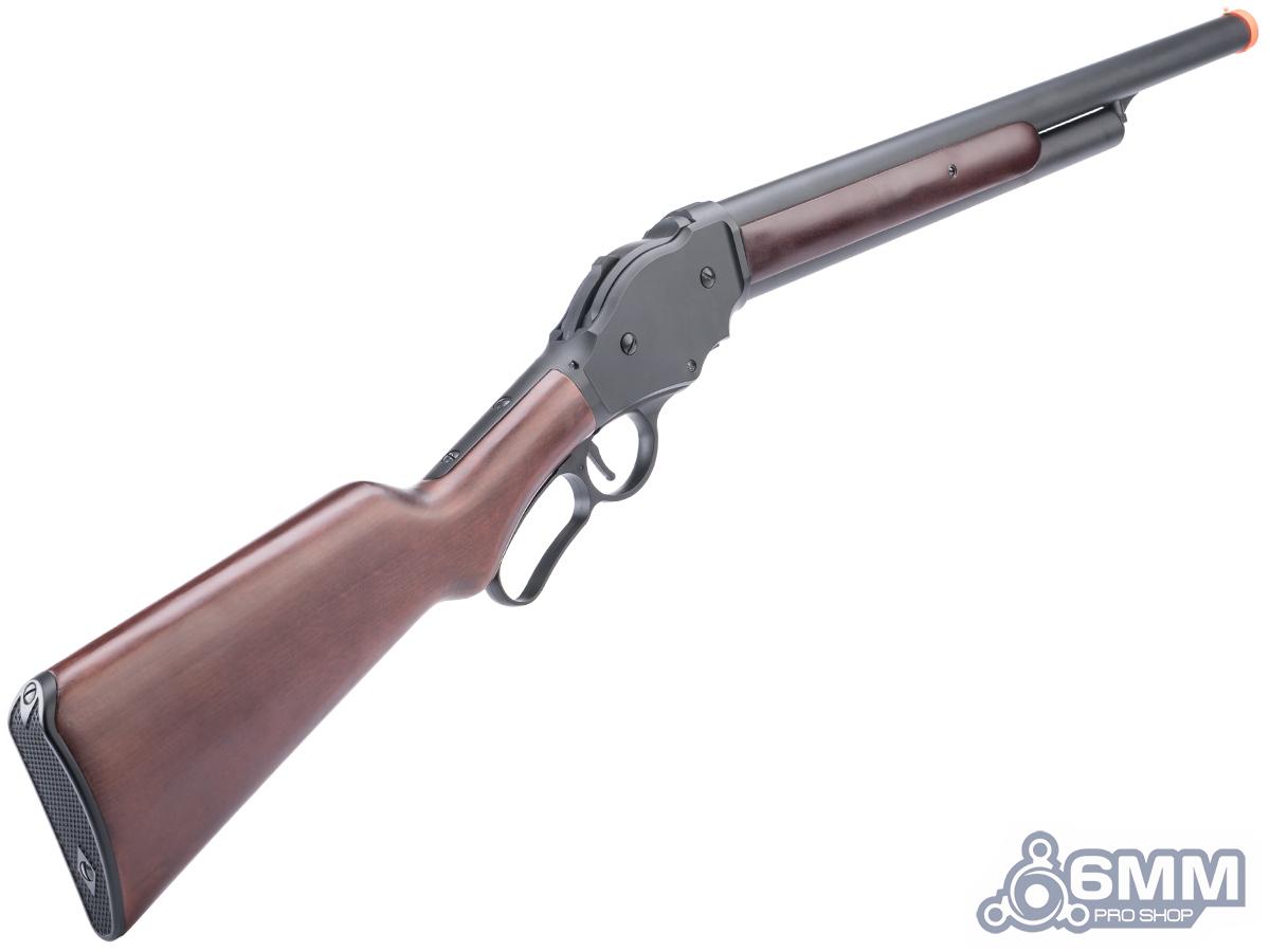 An airsoft lever-action shotgun with a brown wood-grain stock and forend, and a dark gray metal receiver and barrel. It features an orange tip on the barrel, set against a plain white background with a '6MM PRO SHOP' watermark in the bottom right corner.