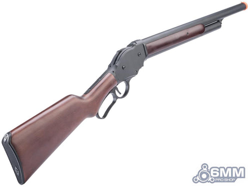 An airsoft lever-action shotgun with a brown wood-grain stock and forend, and a dark gray metal receiver and barrel. It features an orange tip on the barrel, set against a plain white background with a '6MM PRO SHOP' watermark in the bottom right corner.