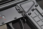 Close-up of a black tactical firearm receiver and magazine with a textured grip and small red markings.