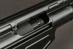 Close-up of a black firearm receiver ejection port area and photographed against a dark gray background.