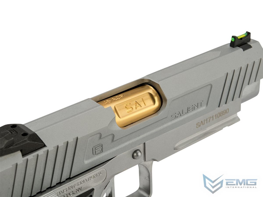 Close-up of a gray handgun with gold slide and EMG logo.