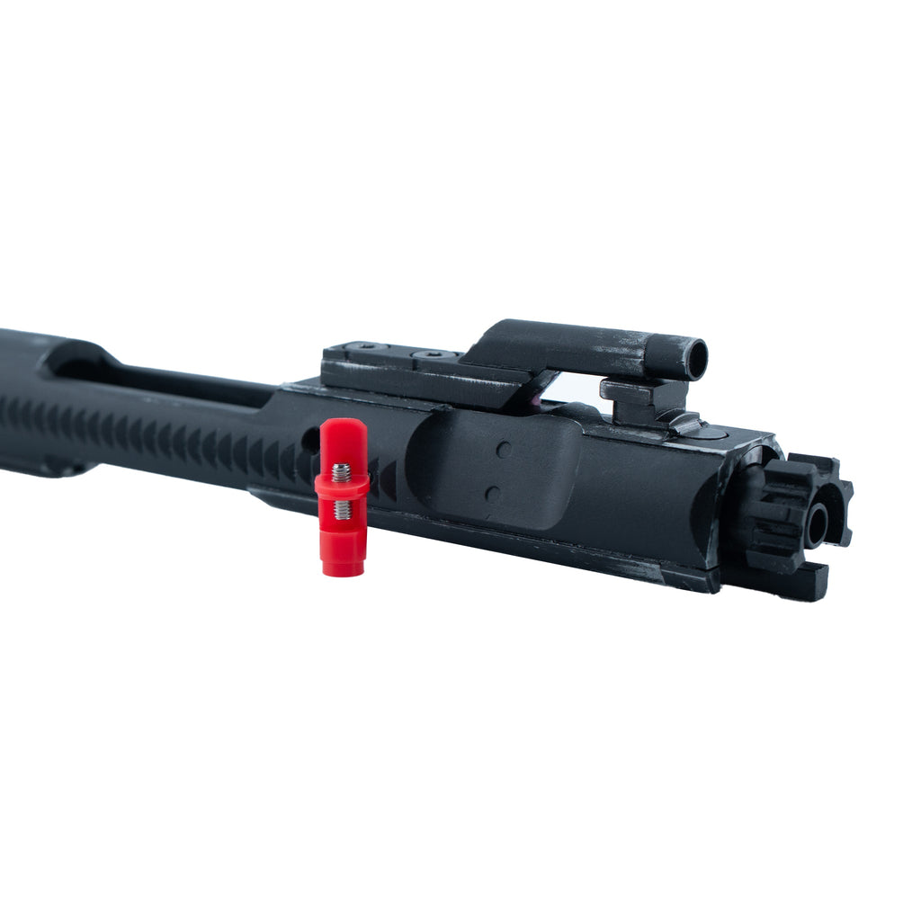 Black firearm slide with red component on a white background