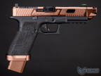 Pistol with rose gold and black finish on a dark background