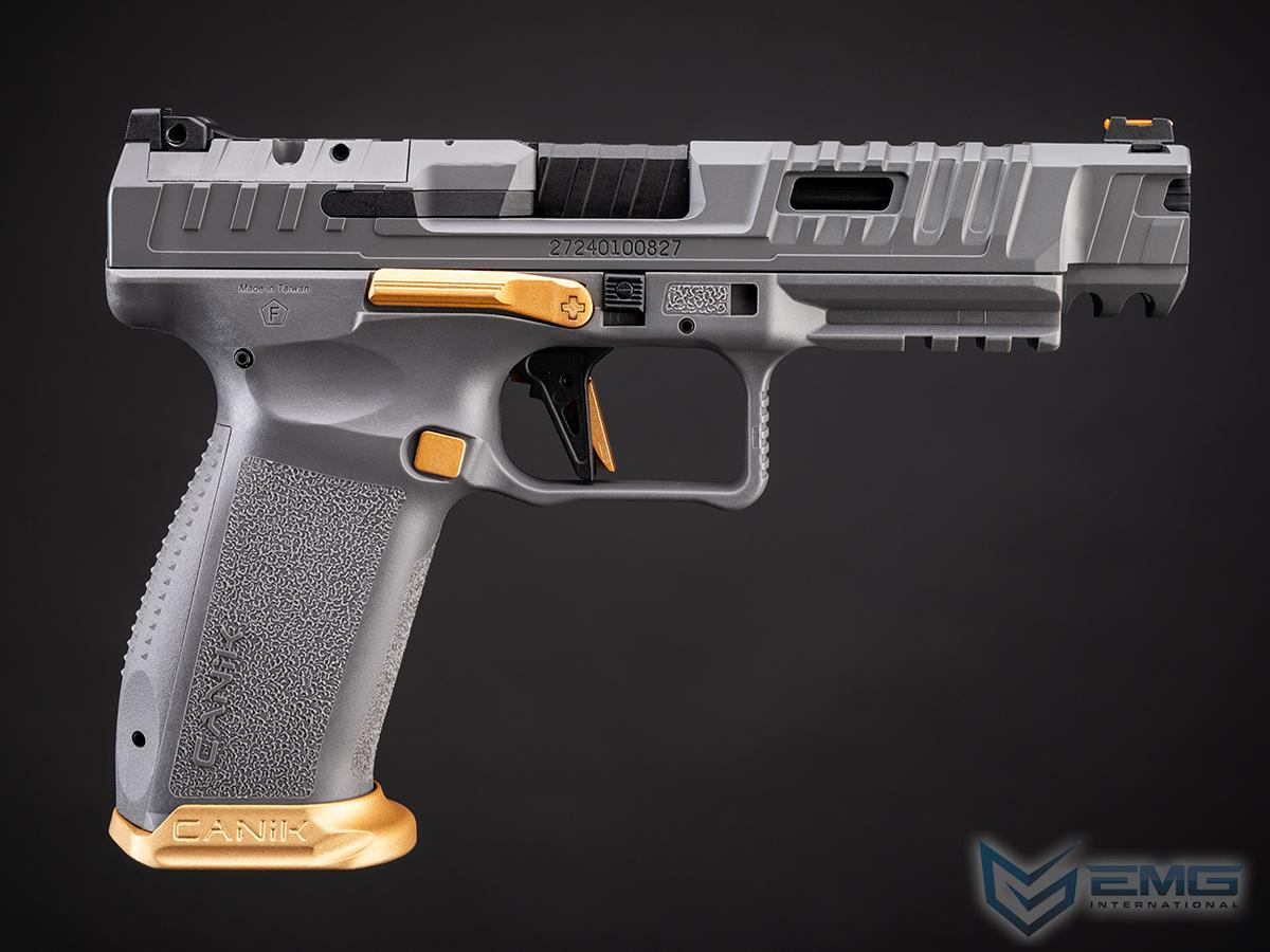 Gray handgun with gold accents on a black background