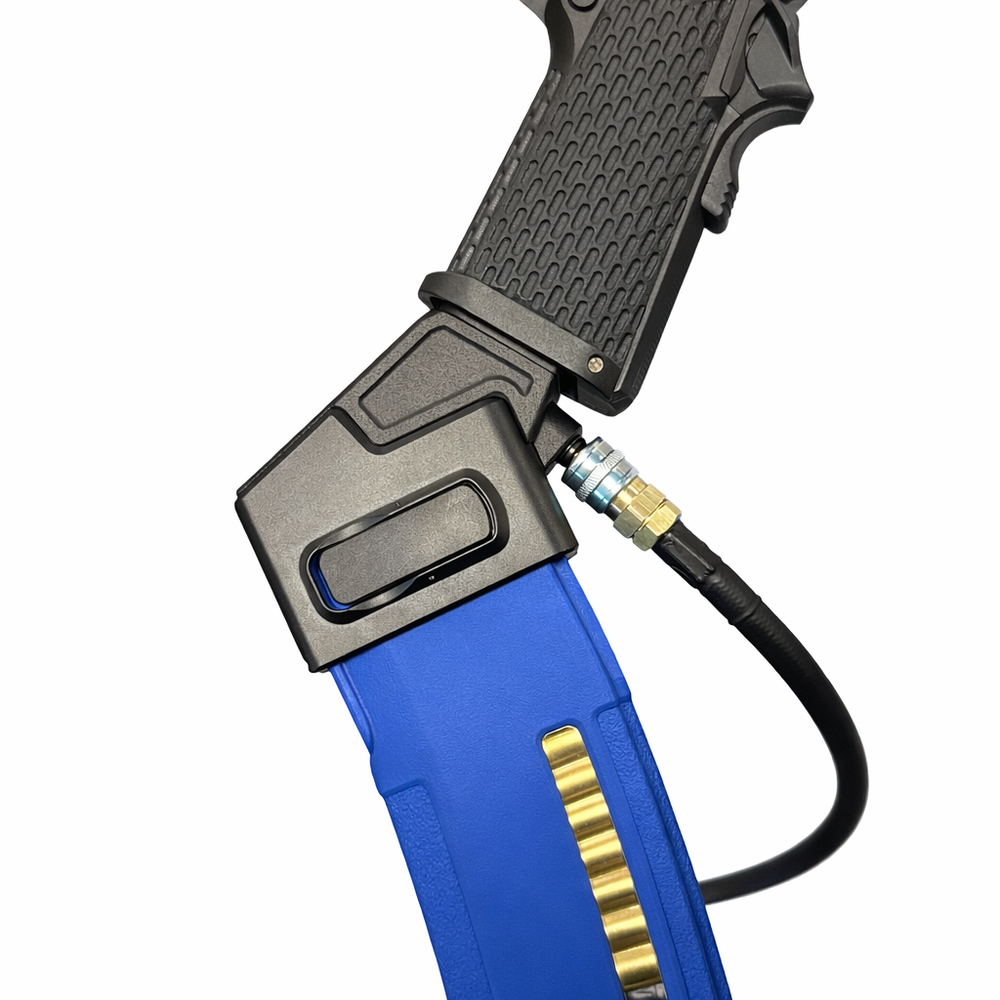 A close-up of a toy or prop pistol with a textured black grip, connected to a blue magazine-like component with a gold-colored metallic accent and a black hose on a plain white background.
