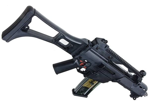 A black tactical-style rifle or airsoft gun with a collapsible stock, vertical foregrip, and attached magazine, shown on a plain white background.