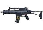 A black tactical submachine gun with a vertical foregrip, adjustable stock, top-mounted rail, and a black magazine with gold-toned metal edges, shown against a plain white background.