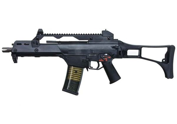 A black tactical submachine gun with a vertical foregrip, adjustable stock, top-mounted rail, and a black magazine with gold-toned metal edges, shown against a plain white background.