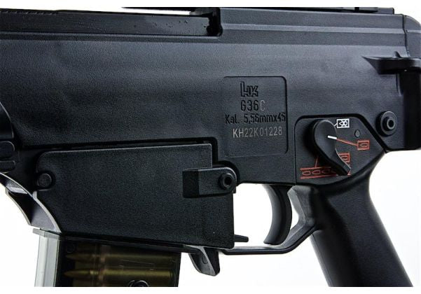 Close-up of a black airsoft rifle receiver with a magazine inserted, featuring a visible 'Lynx' brand stamp and a red-and-black switch on the side.