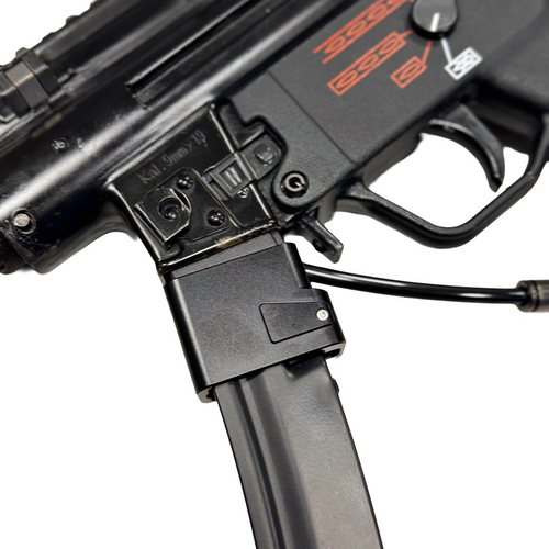 Close-up of a black firearm with visible branding on a white background