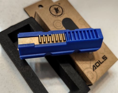Blue tool with gold interior on a white surface with a brown box labeled 'ADLS'.