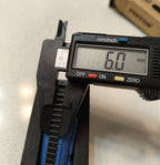 Digital caliper measuring a width of 60mm on a light gray background