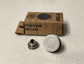 Piston head components and cardboard box on a speckled surface