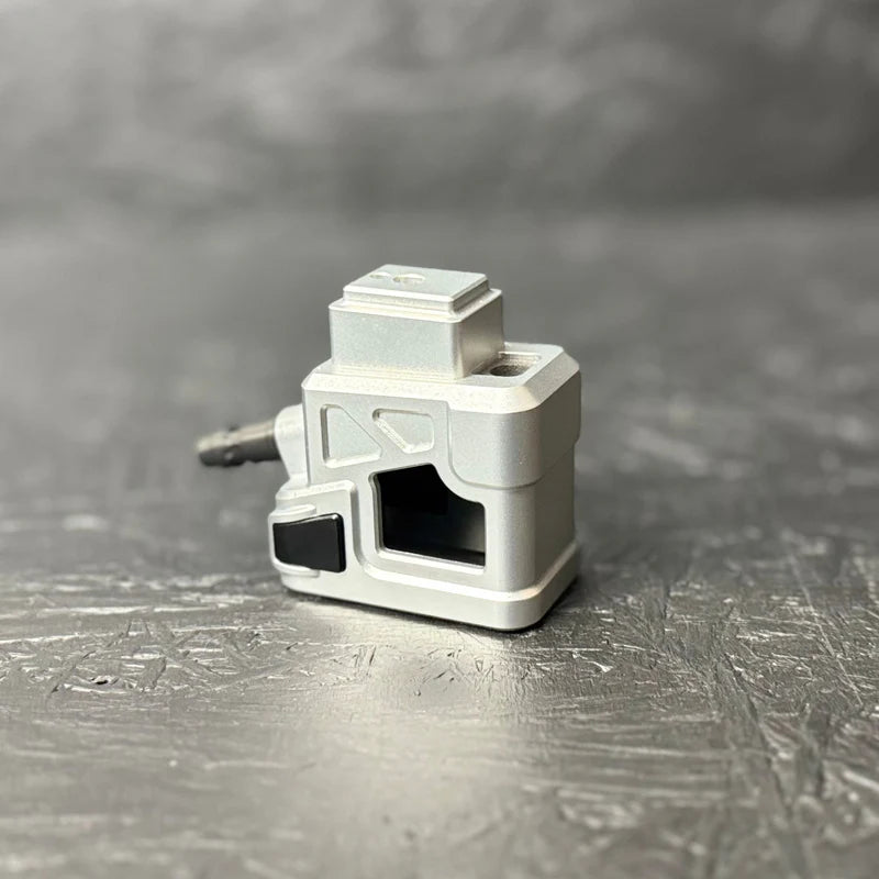 Metallic camera-shaped object on a textured gray surface