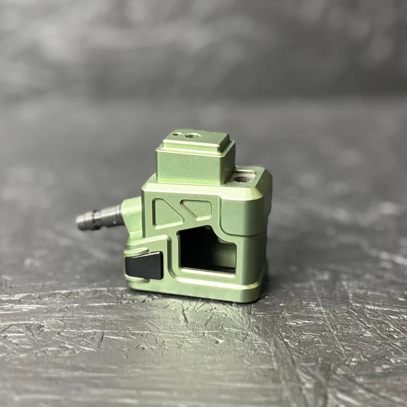 Green metal component on a gray surface