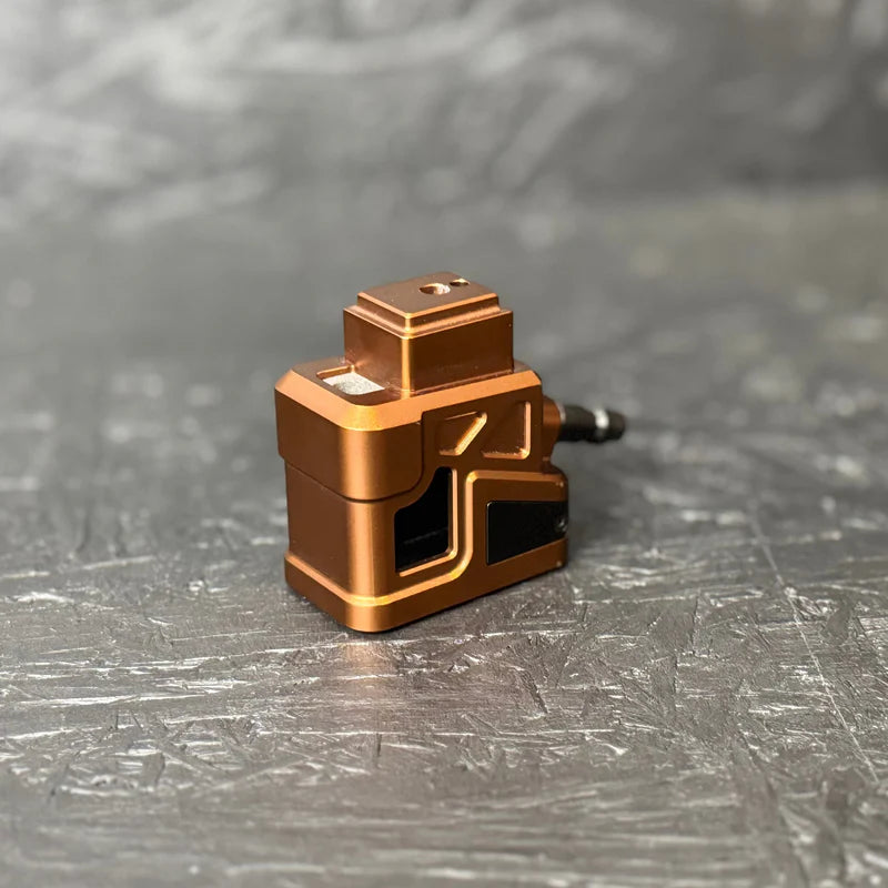 Bronze-colored mechanical component on a gray surface