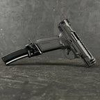 Black handgun with magazine on a gray textured surface