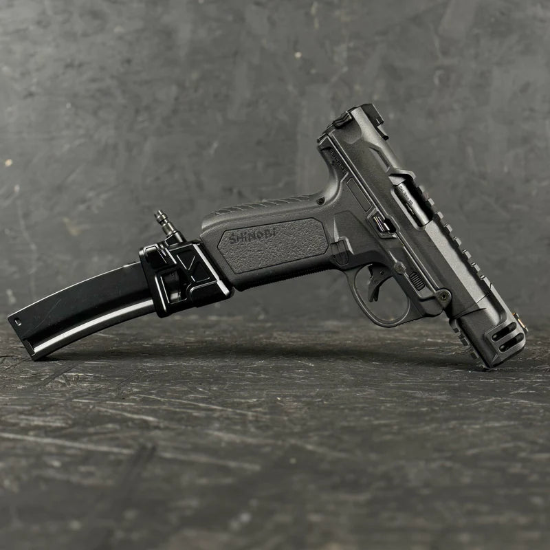 Black handgun with magazine on a gray textured surface
