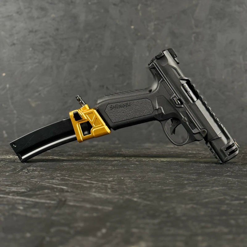 Black handgun with a yellow magazine on a dark textured surface