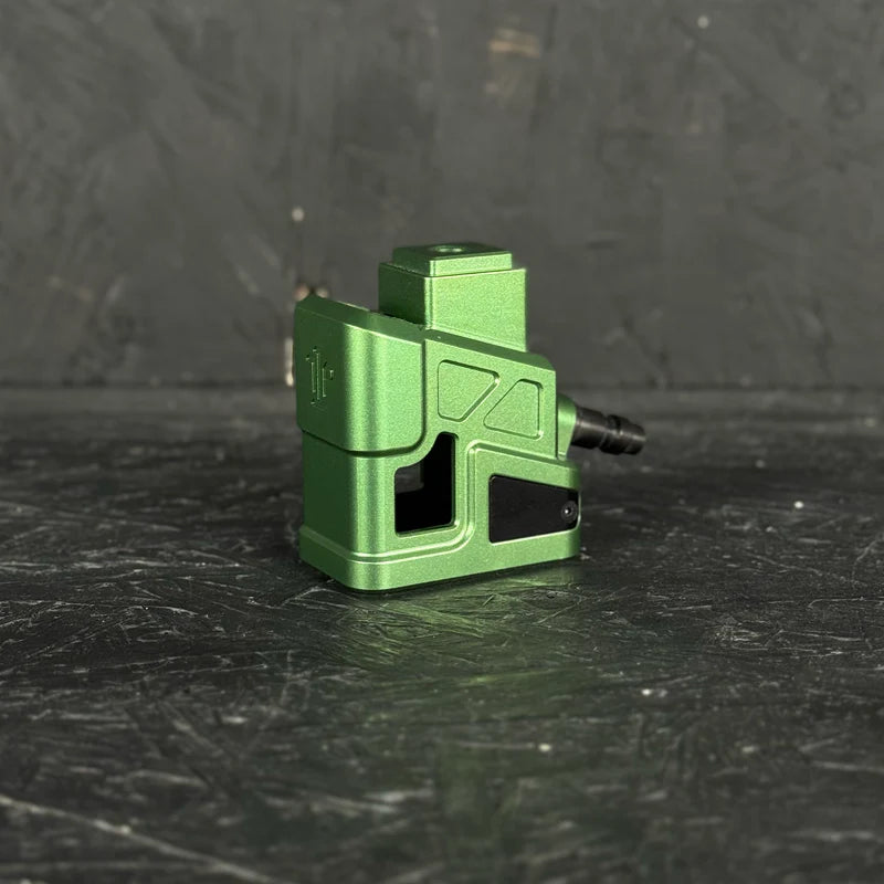 Green mechanical component on a dark textured surface