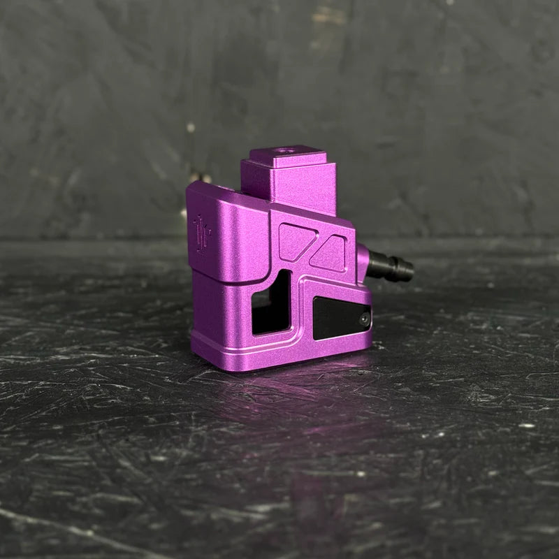 Purple metal component on a black textured surface