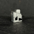 Metallic 3D printer nozzle on a textured black surface