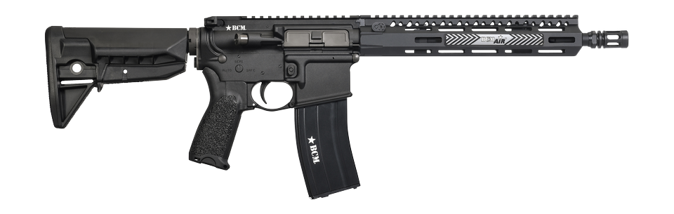 A black tactical rifle with a vertical foregrip, adjustable stock, and a black magazine, shown against a plain white background.